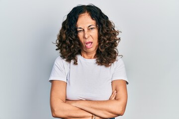 Fototapeta premium Middle age hispanic woman with arms crossed gesture clueless and confused expression. doubt concept.