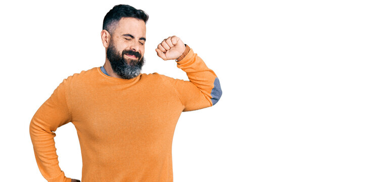 Hispanic man with beard wearing casual winter sweater stretching back, tired and relaxed, sleepy and yawning for early morning - Powered by Adobe