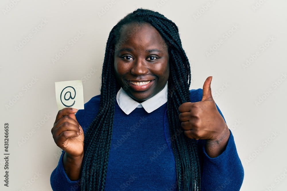 Sticker young black woman with braids holding email symbol on paper smiling happy and positive, thumb up doi