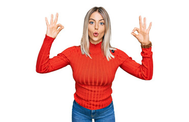 Fototapeta na wymiar Beautiful blonde woman wearing casual clothes looking surprised and shocked doing ok approval symbol with fingers. crazy expression