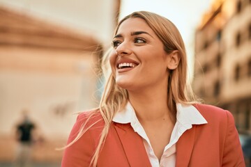 Young blonde businesswoman smiling happy standing at the city.