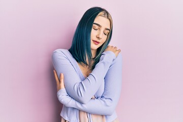 Fototapeta premium Young modern girl wearing casual jacket hugging oneself happy and positive, smiling confident. self love and self care