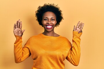Young african american woman wearing casual clothes showing and pointing up with fingers number...