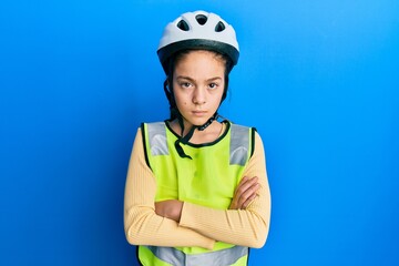 Beautiful brunette little girl wearing bike helmet and reflective vest skeptic and nervous, disapproving expression on face with crossed arms. negative person.