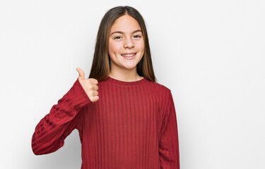 Beautiful brunette little girl wearing casual sweater doing happy thumbs up gesture with hand....