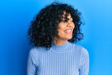 Fototapeta premium Young hispanic woman wearing casual clothes looking to side, relax profile pose with natural face and confident smile.