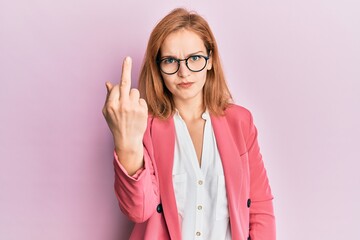 Young caucasian woman wearing business style and glasses showing middle finger, impolite and rude fuck off expression