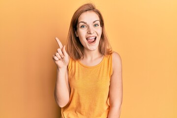 Young caucasian woman wearing casual style with sleeveless shirt showing and pointing up with...