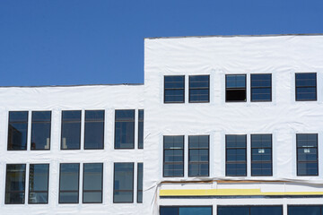 Construction of new building with windows and wrap still on exterior before installation of...