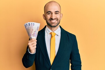 Young hispanic business man holding russian 500 ruble banknotes looking positive and happy standing...