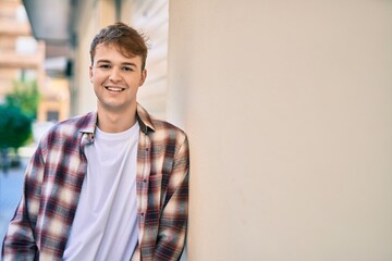 Obraz premium Young caucasian man smiling happy standing at the city.