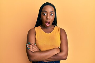 Young african american woman with arms crossed gesture afraid and shocked with surprise and amazed expression, fear and excited face.