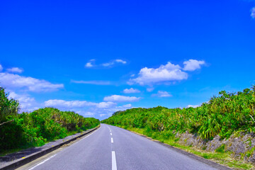 沖縄県宮古島。池間大橋手前のカーブのある道路と青空
