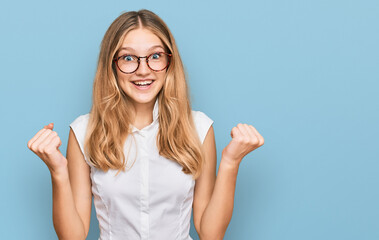 Beautiful young caucasian girl wearing casual clothes and glasses celebrating surprised and amazed for success with arms raised and open eyes. winner concept.