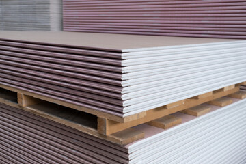 The stack of Plasterboard fire-resistant gypsum board cardboard surface Panel Type DF for indoor concrete walls prepared for construction - obrazy, fototapety, plakaty
