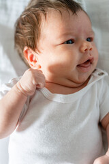 Naklejka premium Top view on newborn baby lying on bed at home in white one month four weeks old