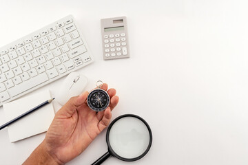 Businessman looking at a compass which he is holding in his hand, Businessman with a compass...