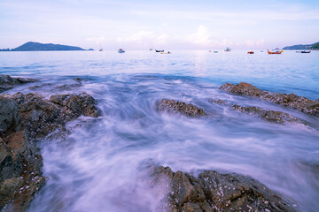 Beautiful long exposure seascape with sea wave forms a dense white foam on the rocks seashore Seascape background at Phuket Thailand