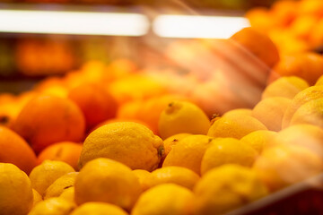 Heap of fresh fruits oranges and lemons on a shop window.