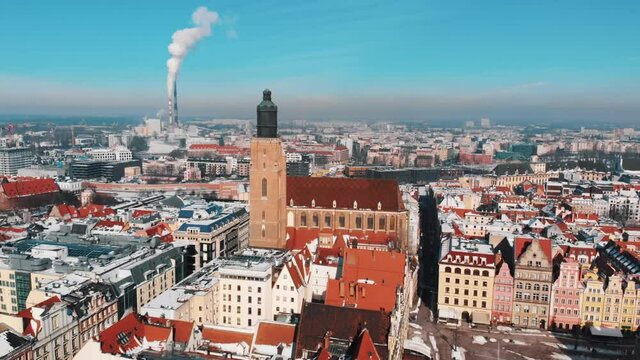 Aerial view of the smoke coming out of chimneys of the CHP plant and the city's buildings - Wroclaw, Poland. Clear sky background. Daytime. Old town city. High-quality 4K. 