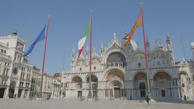 Flags in Saint Mark's Piazza with church in Venice, Italy. (Venezia, Italia) 4k