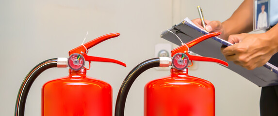 Fire extinguisher, Firefighter checking pressure gauge level of fire extinguisher tank in the...