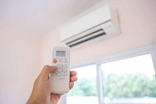 Close up remote set adjust temperature at 25 degrees of air conditioner split type wall mounted in home room concepts of cool or heat air cleaner and service repairing and maintenance.