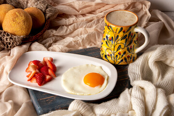 Fried egg with chopped strawberries and cocoa drink