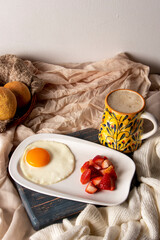 Fried egg with chopped strawberries and cocoa drink