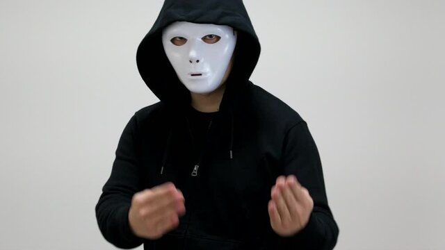 Hacker with anonymous mask showing gesture of "Come here"