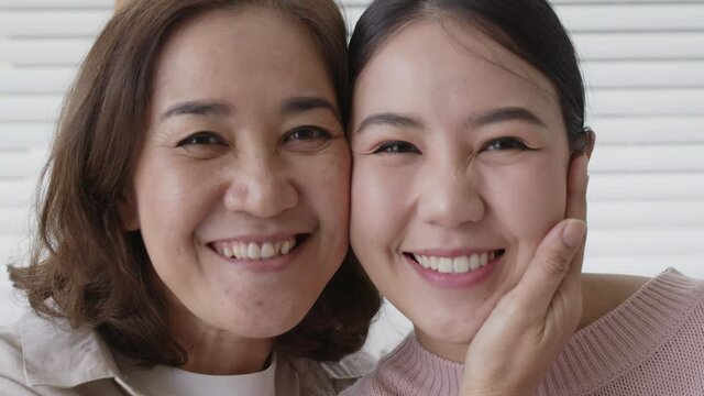 Close up attractive beautiful two asia people face cheek smile to camera authentic real family mum and adult kid in woman power day, diverse ethnic people, genes genetics ginger mom skincare concept.