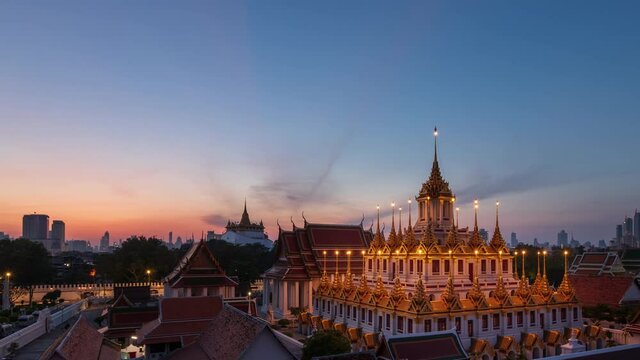 Loha Prasat or Iron Castle Monastery at Wat Ratchanatdaram temple, on Ratchadamnoen Avenue during morning, Bangkok, Thailand; night to day, zoom out &ndash; time lapse
