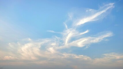 Streak of white clouds on the blue sky. Light clouds in the afternoon reflecting the beautiful sunlight.
