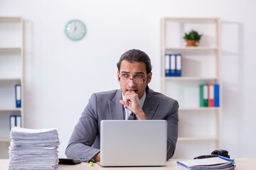 Young male employee unhappy with excessive work in the office