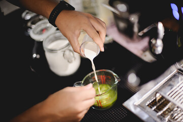 The barista is pouring the coffee mixture.