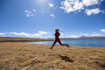 Woman trail runner cross country running on winter lakeside