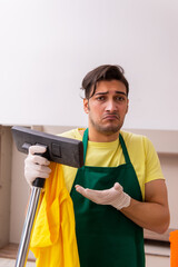 Young male contractor cleaning the house indoors