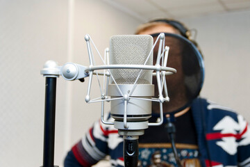 Studio microphone for professional recording. In the background, the man recording a voice. The sound recording studio. 