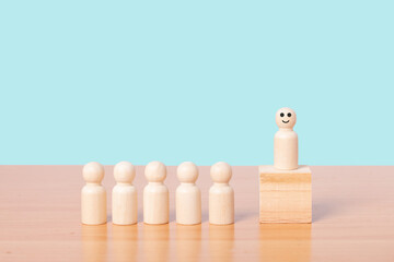 Wood person model standing on the podium among people. Leadership concept.