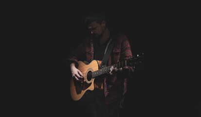 Male guitarist playing acoustic guitar copy space.