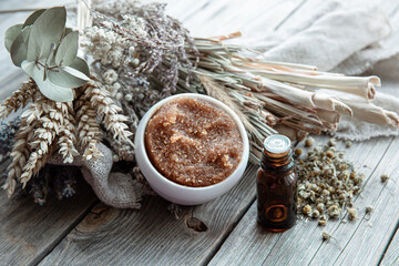 Close-up of natural body scrub, oils and dry field herbs.