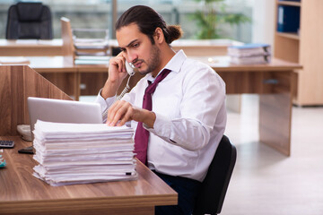 Young male employee and too many work in the office