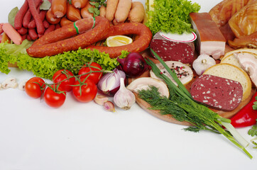 Meat products, ham and smoked products surrounded by spices and vegetables.