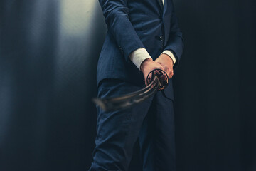 日本刀を構えるスーツ姿の人物
