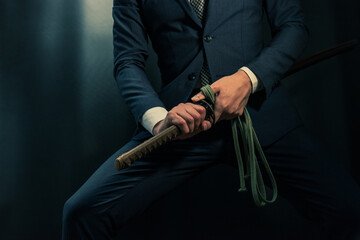 日本刀を構えるスーツ姿の人物