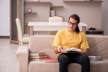 Obraz premium Young male student preparing for exams at home
