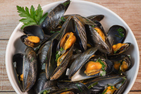Moules mariniere, mussels, with cream, garlic and parsley in a iron bowl, Delicious French food, High quality photo