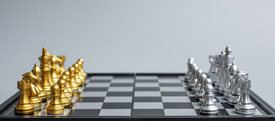 silver and gold Chess figure on Chessboard against opponent during battle. Strategy, Success, management, business planning, think, education and leader concept