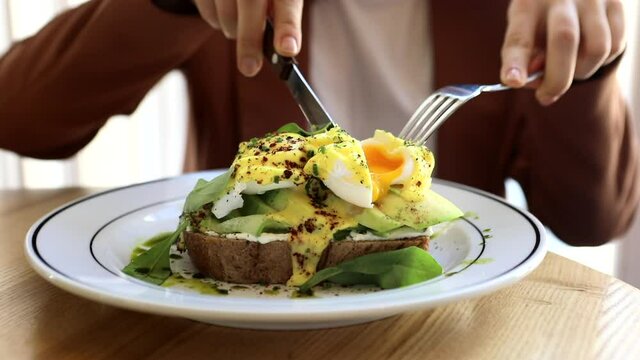 Woman Eating At Cafe Sandwich Eggs Benedict Avocado