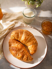 Morning breakfast, light background, croissants and jam. Milk. French style, restaurant or hospitality business